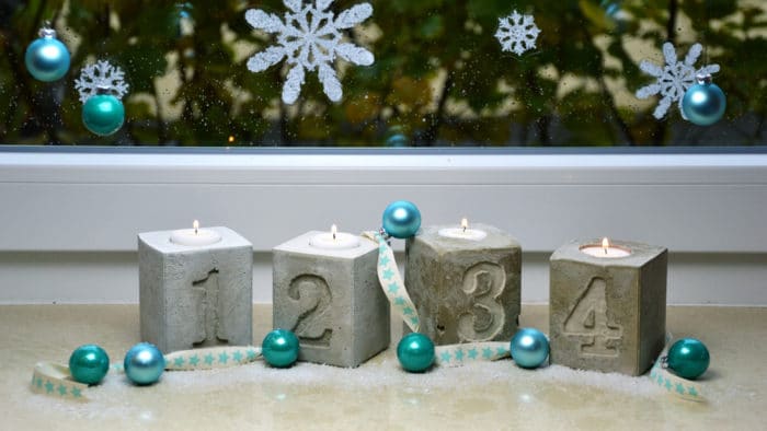 Der Adventskranz aus Beton kann mit kühlen Farben gut kombiniert werden, wie zum Beispiel blau.