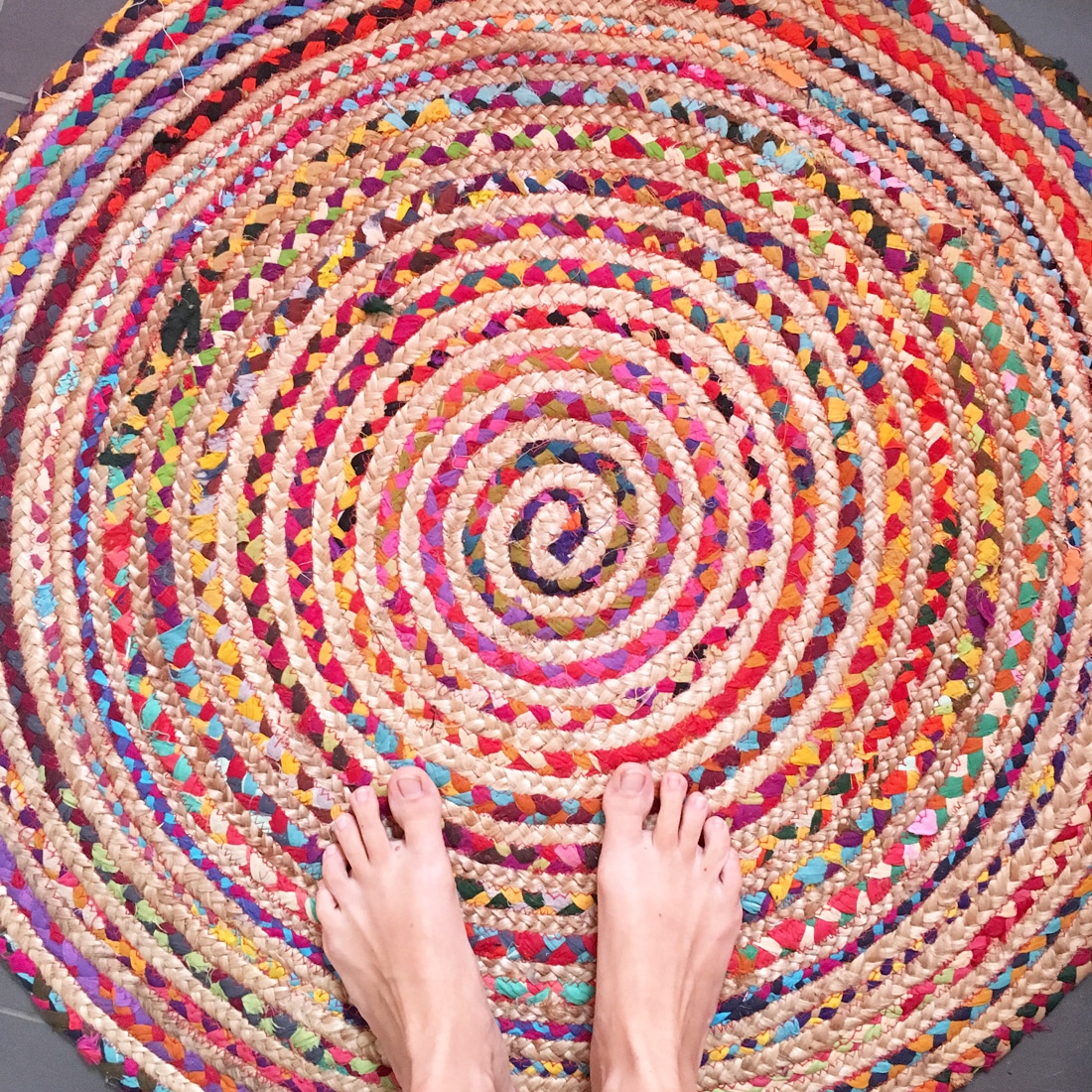 Nackte Füße auf kunterbuntem Teppich